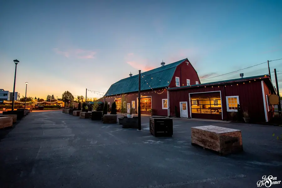 The red barn at Rossi Farms at dusk with its lights on