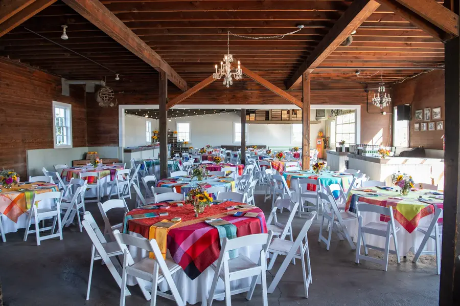 The barn at Rossi Farms set for a dinner, long rows of tables with flowers