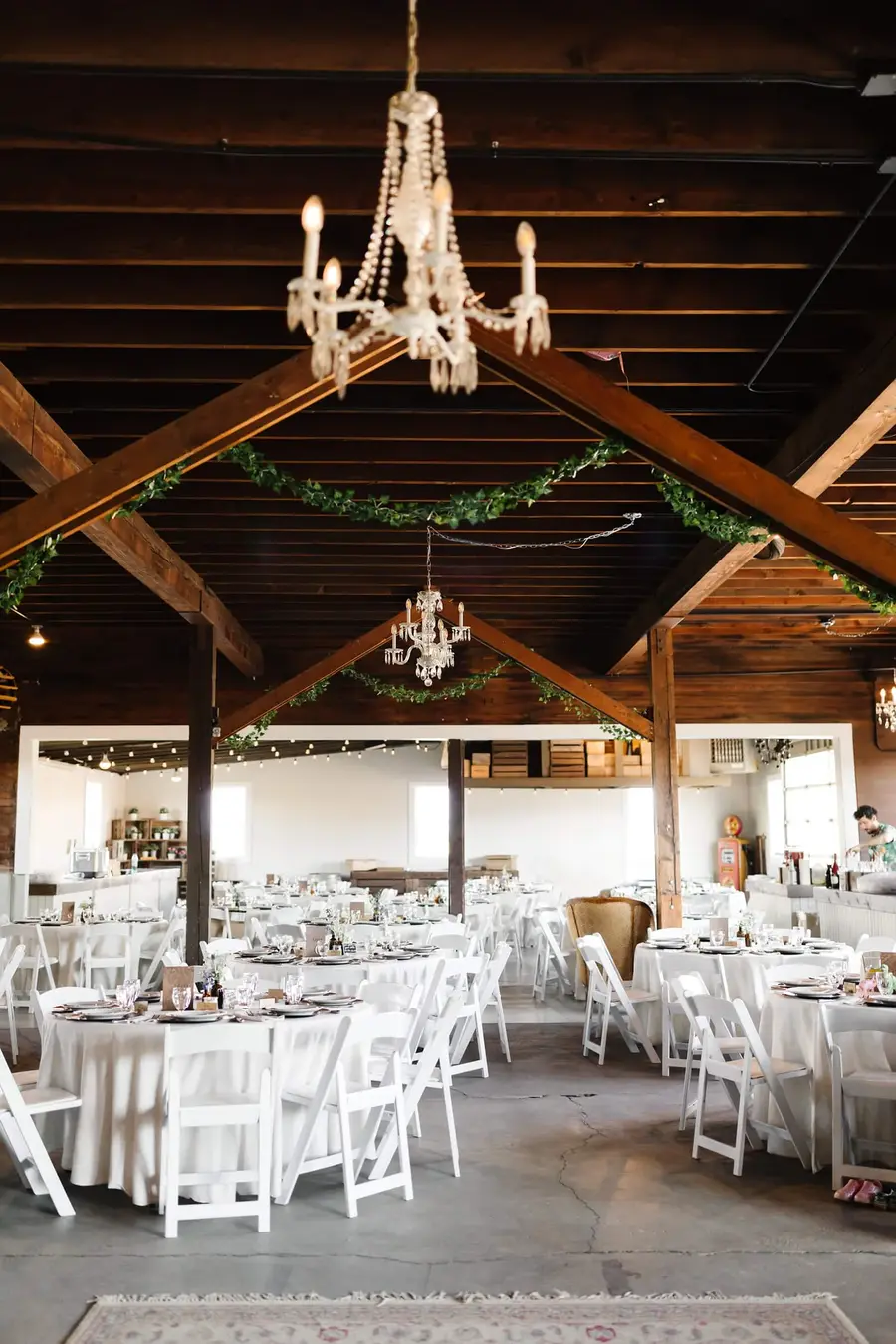 Inside the barn at Rossi Farms, tables set under a chandelier